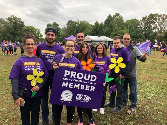 Dime Community Bank employees holding up a sign at a volunteer event.