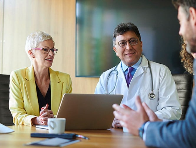 A doctor talking to 3 other people.