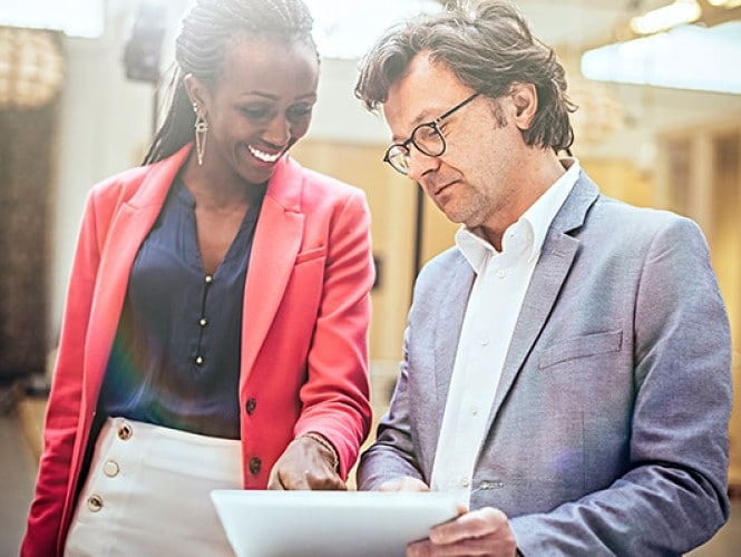 Two people reviewing a document. 