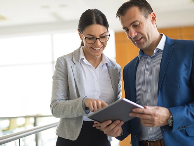 Two people looking at a tablet.
