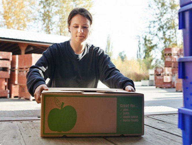 Someone moving a box of apples.