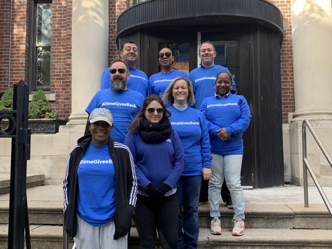 Dime Community Bank employees standing in front of the Brooklyn public library. 