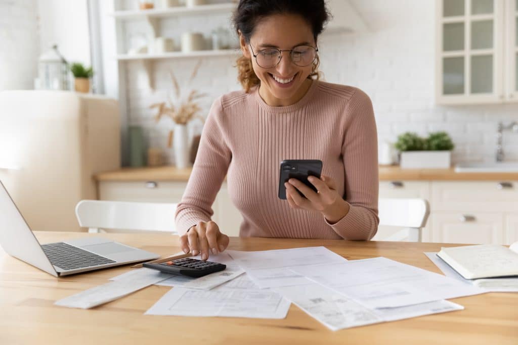 A woman looking at her phone smiling. 