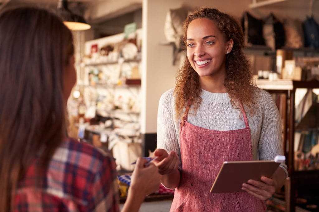 A woman handing her bank card to a worker.